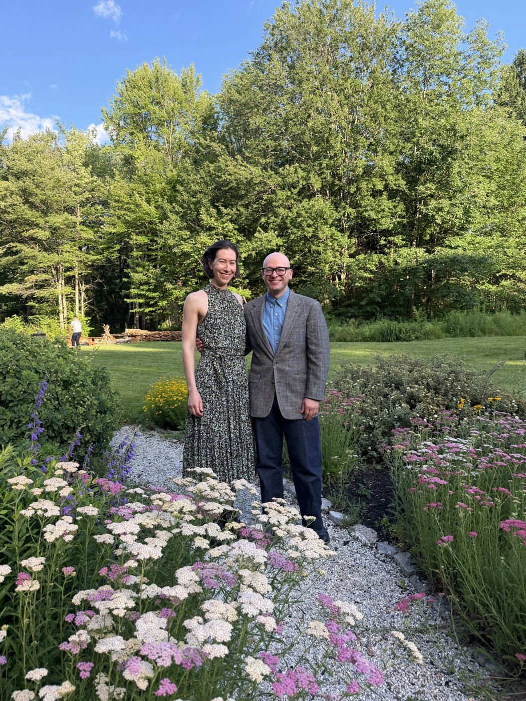 Becca in a garden in a long patterned dress