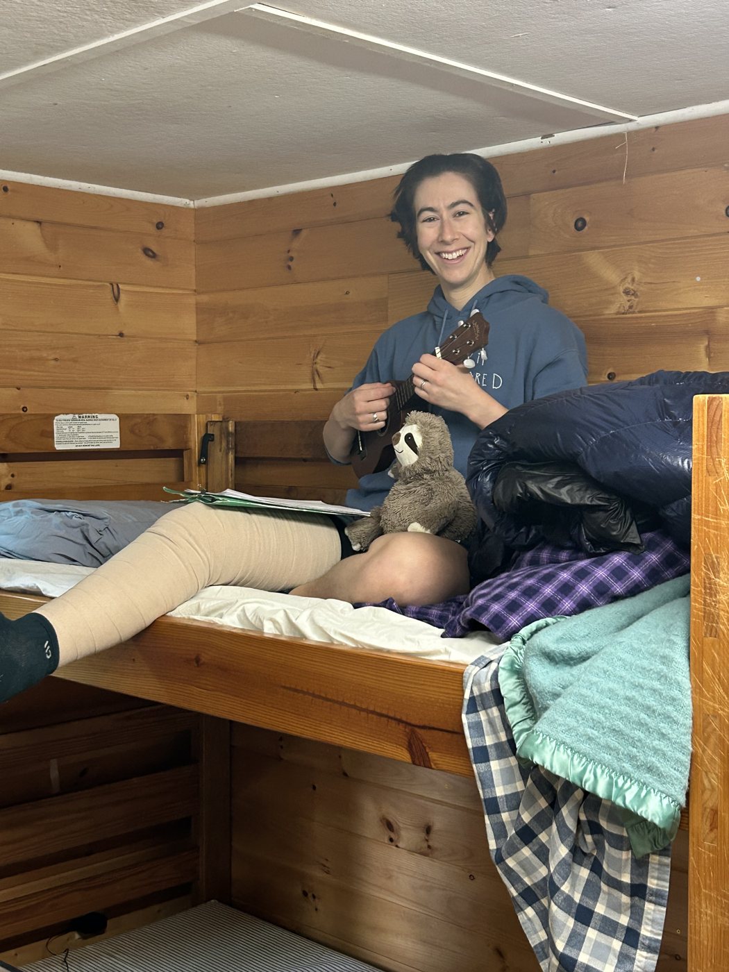 Becca in a cabin bunk with Slothie